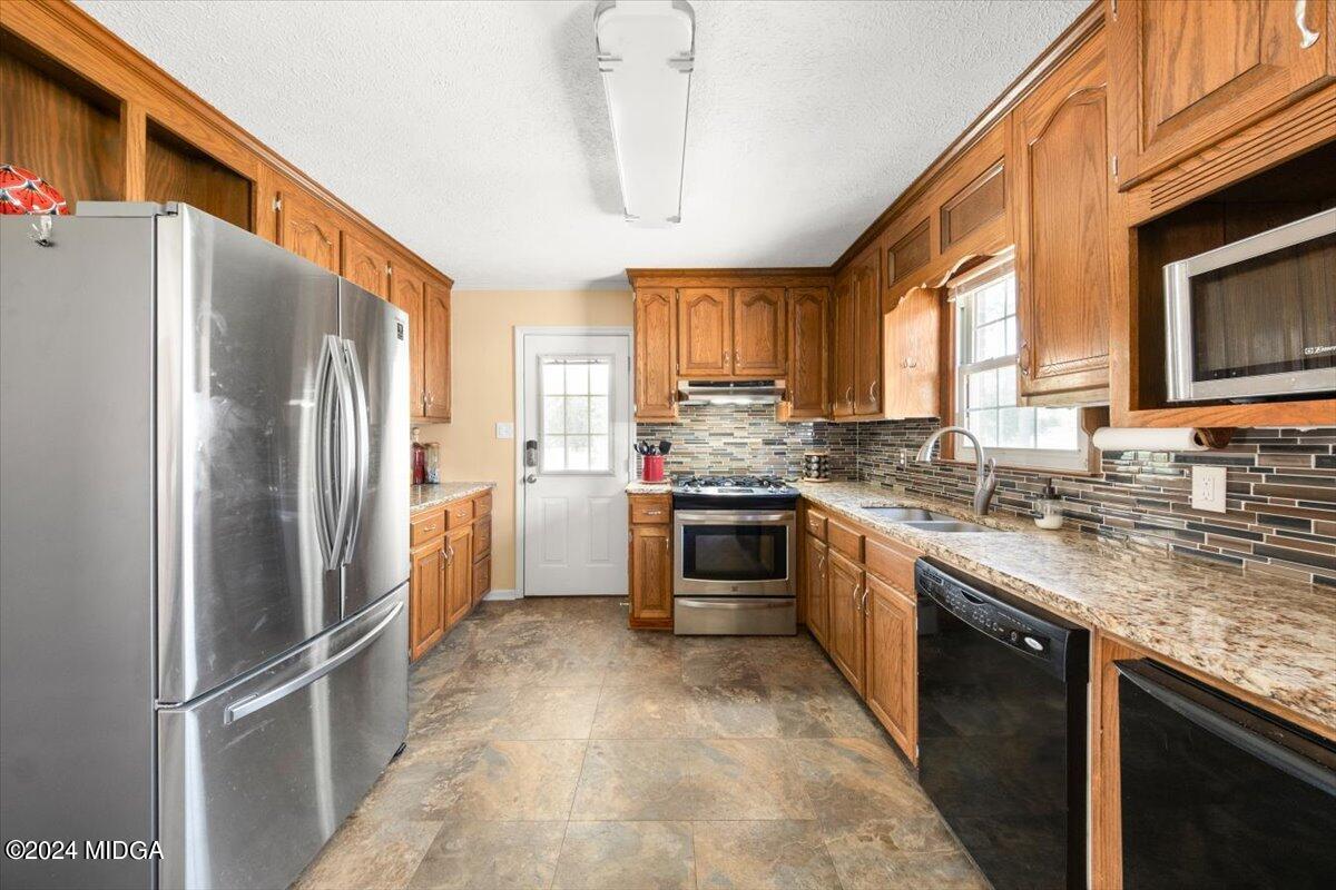 3645 Tidwell Road Lizella, GA 31052 - Photo 2 of 26 a kitchen with granite countertop a refrigerator stove top oven a sink and dishwasher