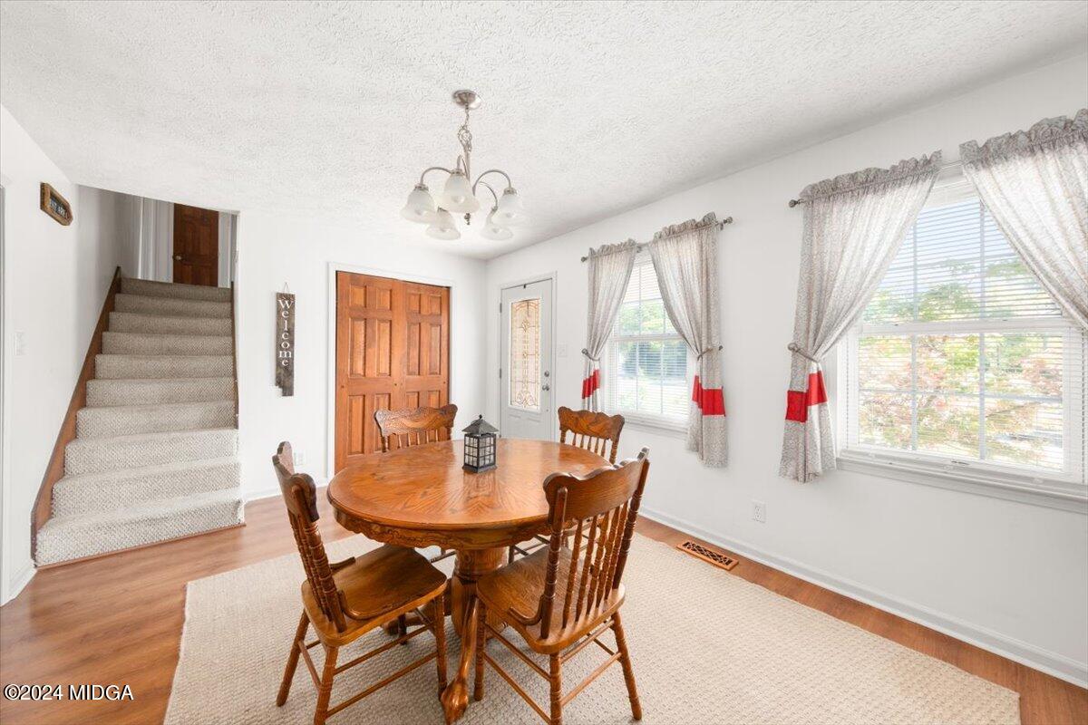 3645 Tidwell Road Lizella, GA 31052 - Photo 3 of 26 a view of a dining room with furniture wooden floor and chandelier