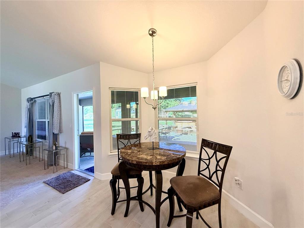 9832 Southwest 46th Court Ocala, FL 34476 - Photo 19 of 53 a view of a dining room with furniture window and wooden floor