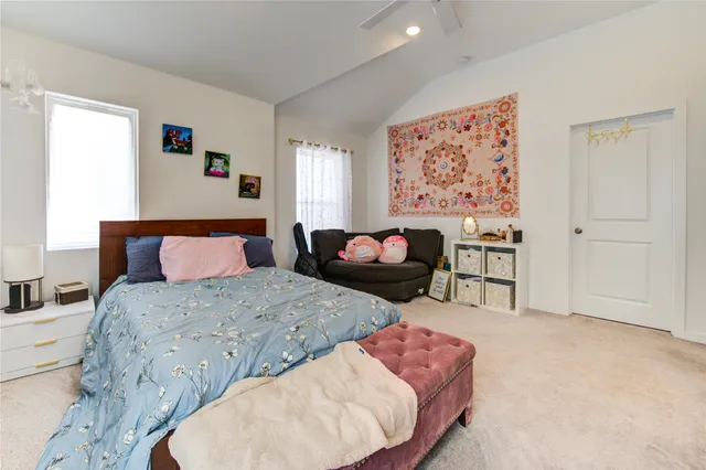 a bedroom with a bed furniture flat screen tv and a window
