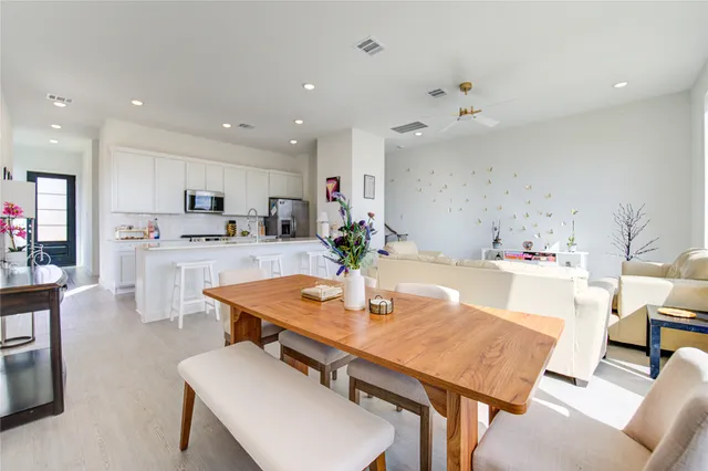 a hallway with a couch and a dining table next to a window