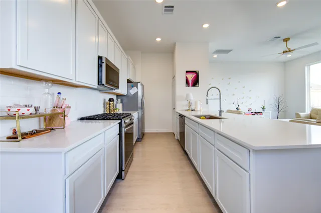a kitchen with kitchen island granite countertop a sink and stove top oven