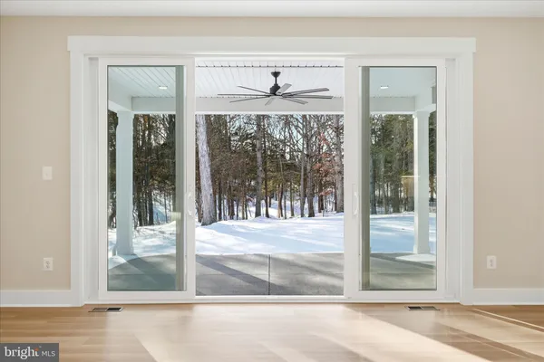 a view of a room with a floor to ceiling window and front door