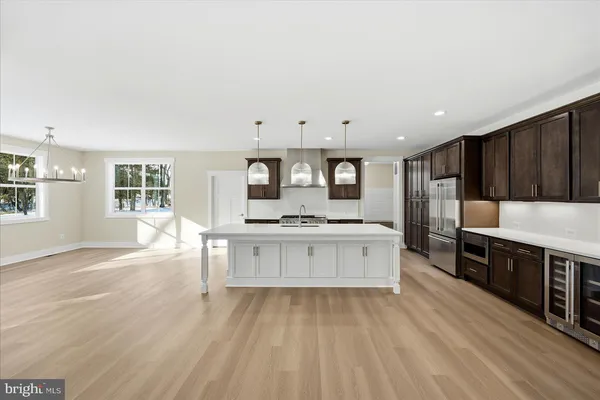 a large kitchen with kitchen island a sink dishwasher stove and cabinets with wooden floor