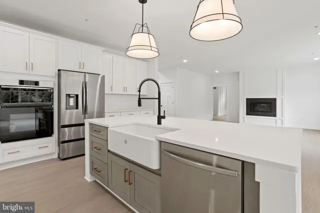 a view of a kitchen with a stove cabinets a ceiling fan and wooden floor