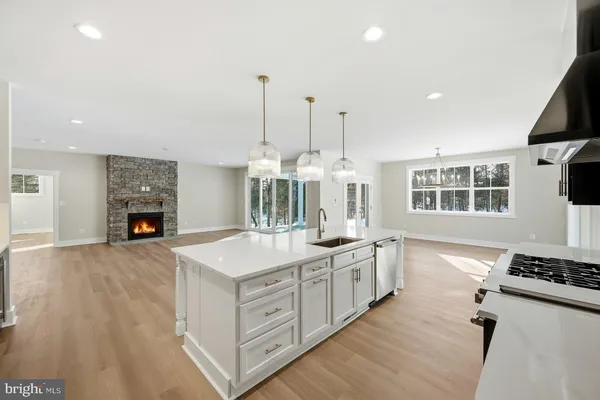 a large kitchen with stainless steel appliances granite countertop a stove and a wooden floors