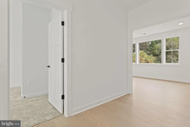 a view of a hallway with wooden floor and a window