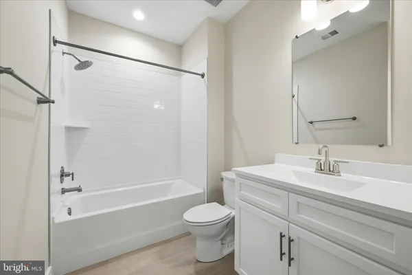 a bathroom with a sink a mirror toilet and bathtub