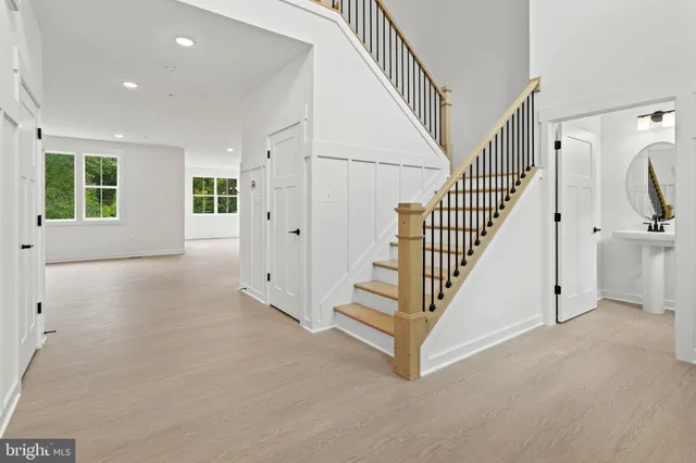 a view of a hallway with wooden floor and staircase