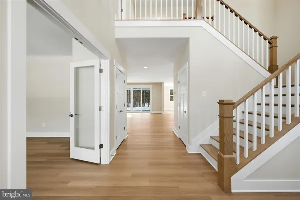 a view of a hallway with wooden floor and staircase