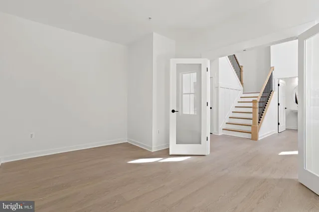 an empty room with windows and fireplace