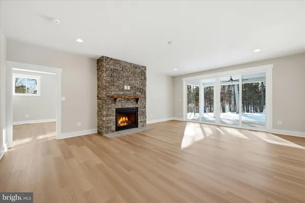 a view of an empty room with wooden floor and a fireplace