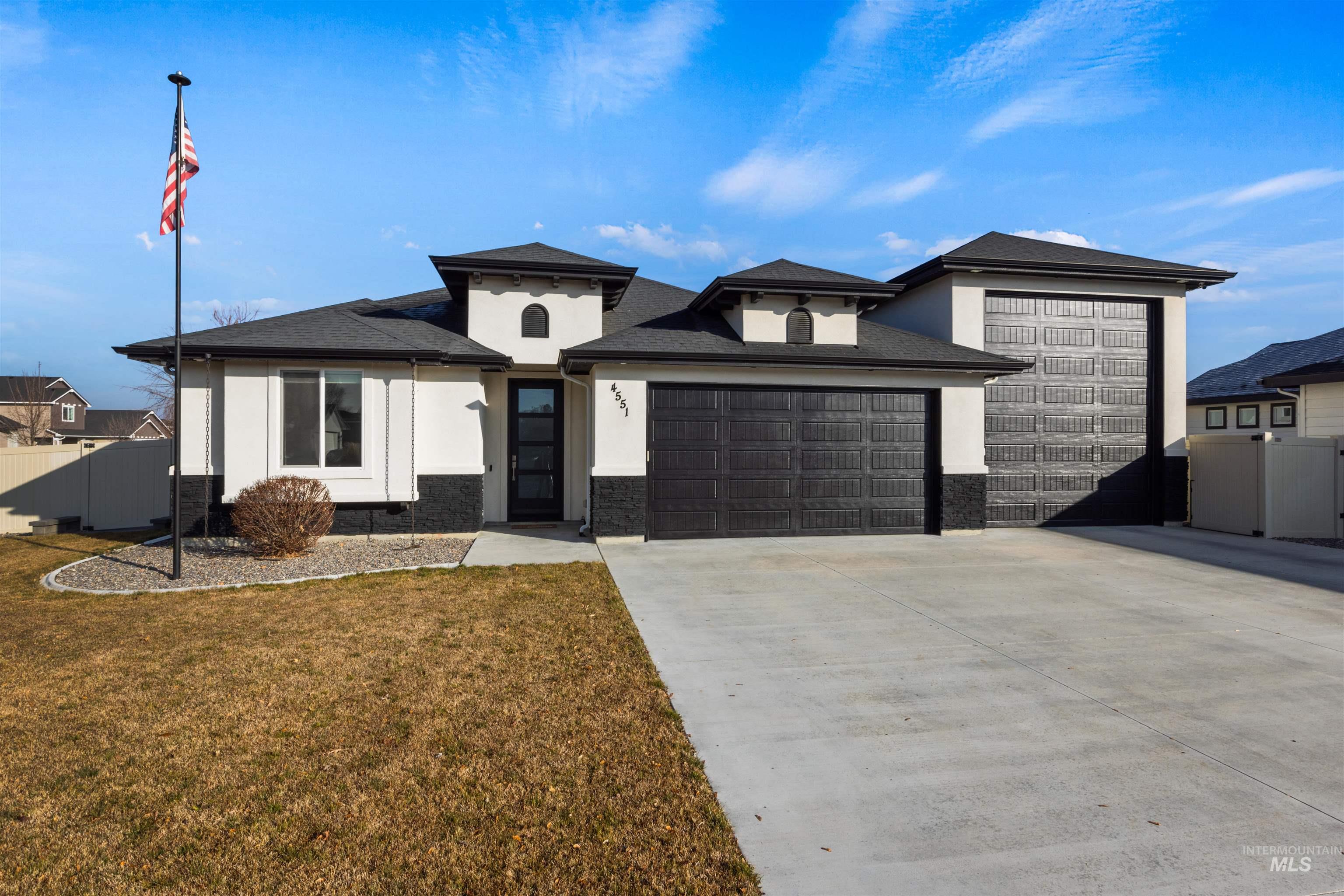 Prairie-style home featuring an attached garage, stucco siding, concrete driveway, and stone siding