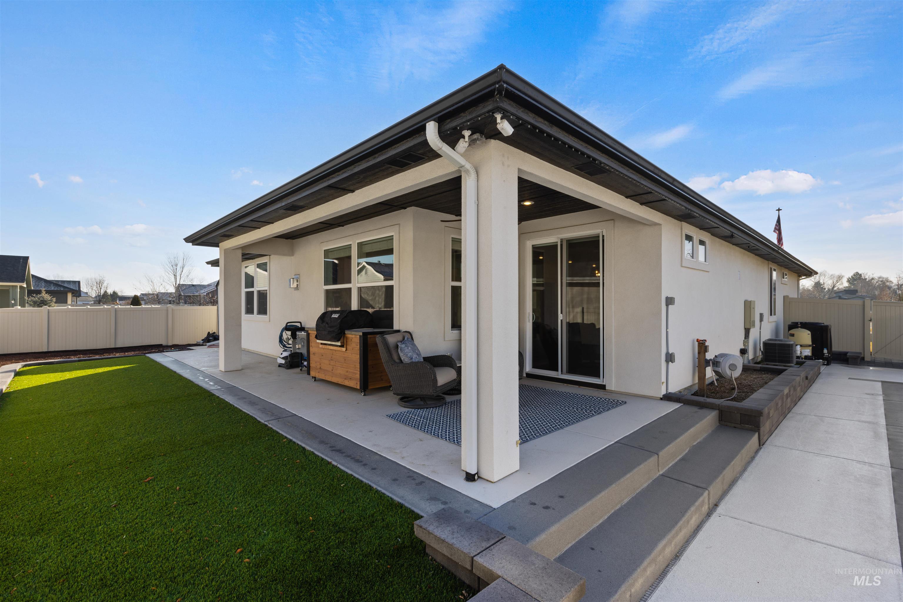4551 South Lava Springs Loop Nampa, ID 83686 - Photo 7 of 49 Rear view of property featuring a fenced backyard, a patio, stucco siding, and a gate