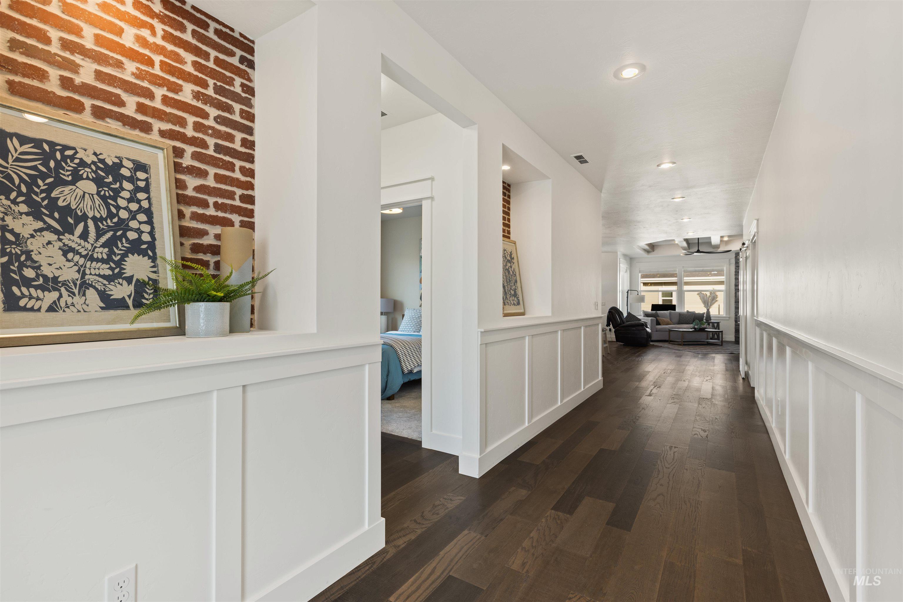 4551 South Lava Springs Loop Nampa, ID 83686 - Photo 9 of 49 Hall featuring dark wood finished floors, a decorative wall, recessed lighting, and a wainscoted wall