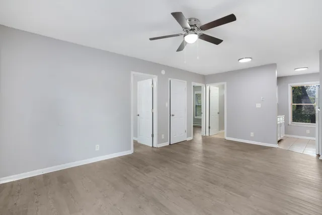 an empty room with wooden floor and windows