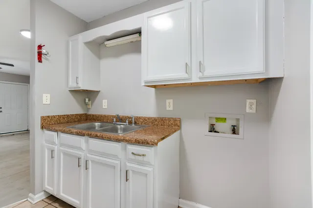 a kitchen with granite countertop white cabinets and a sink