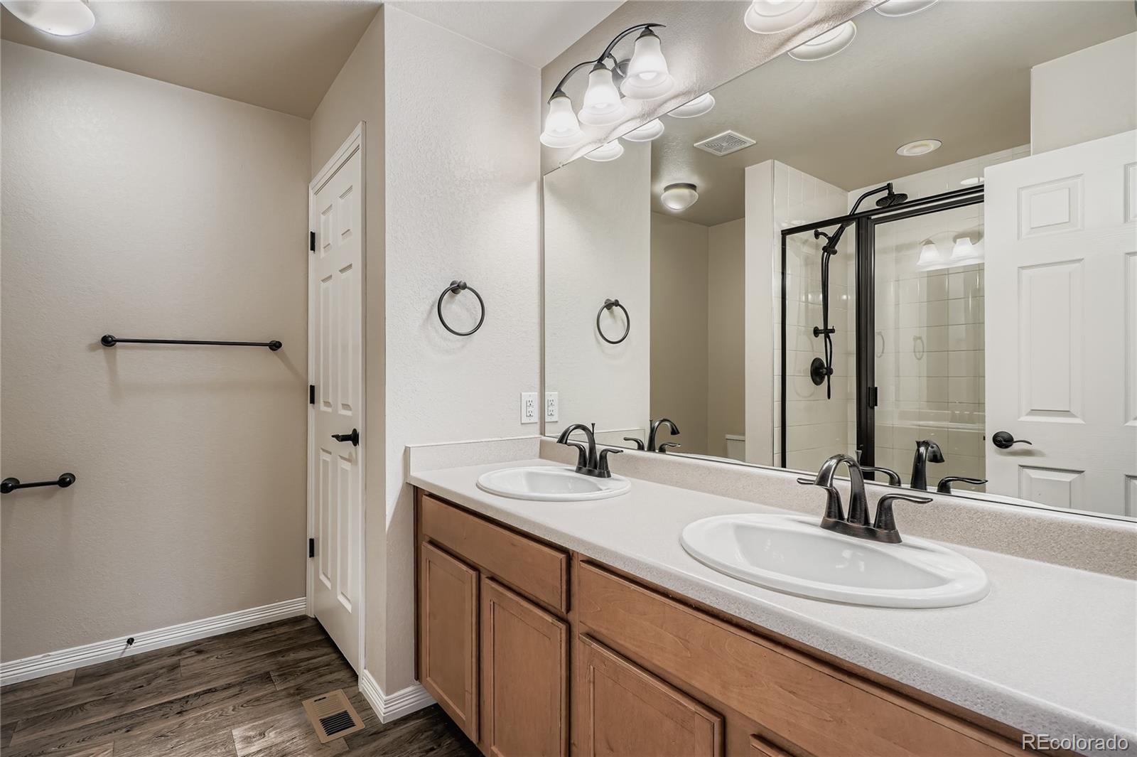 4767 Memphis Street Denver, CO 80239 - Photo 11 of 17 a bathroom with a double vanity sink mirror and shower