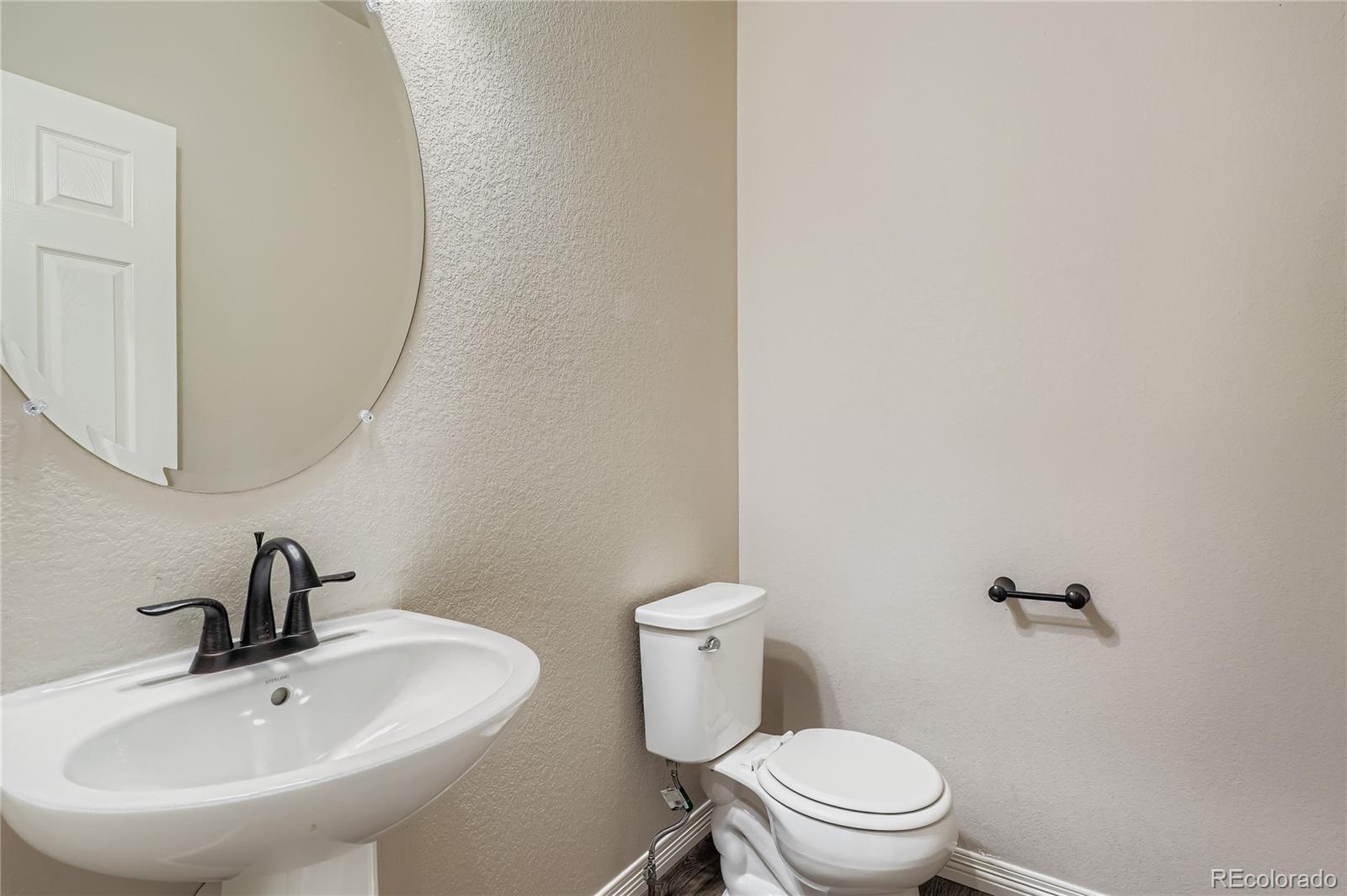 4767 Memphis Street Denver, CO 80239 - Photo 13 of 17 a white toilet sitting next to a bathroom sink