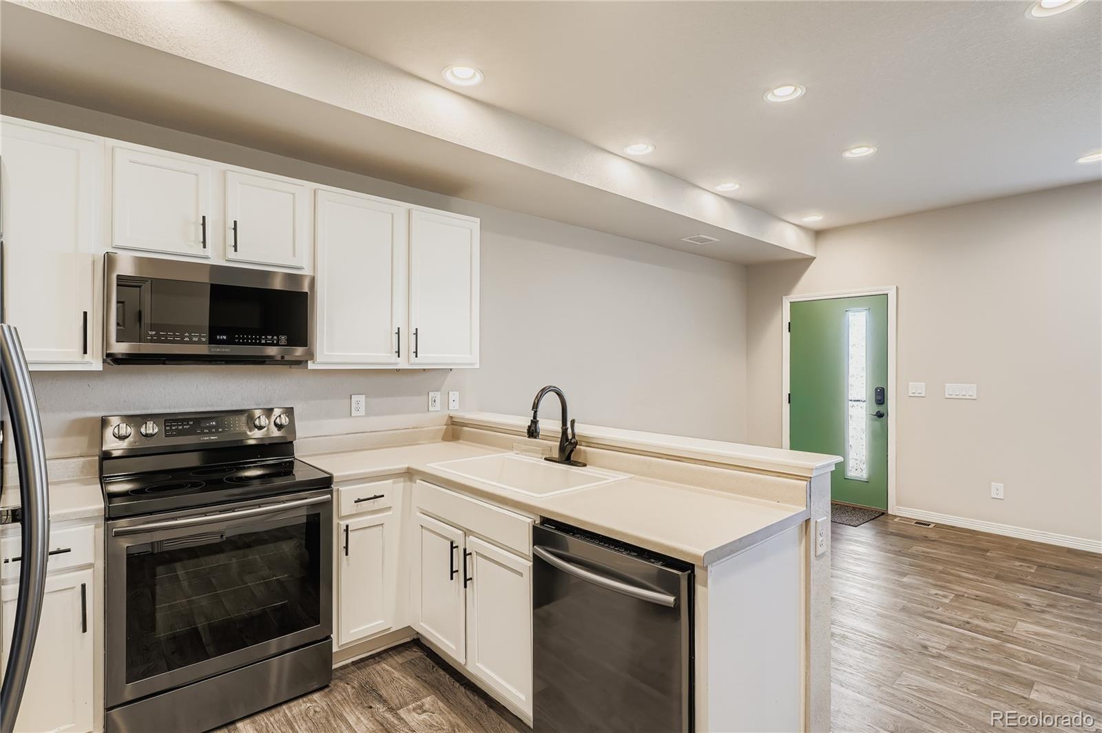 4767 Memphis Street Denver, CO 80239 - Photo 3 of 17 a kitchen with a sink stove and microwave