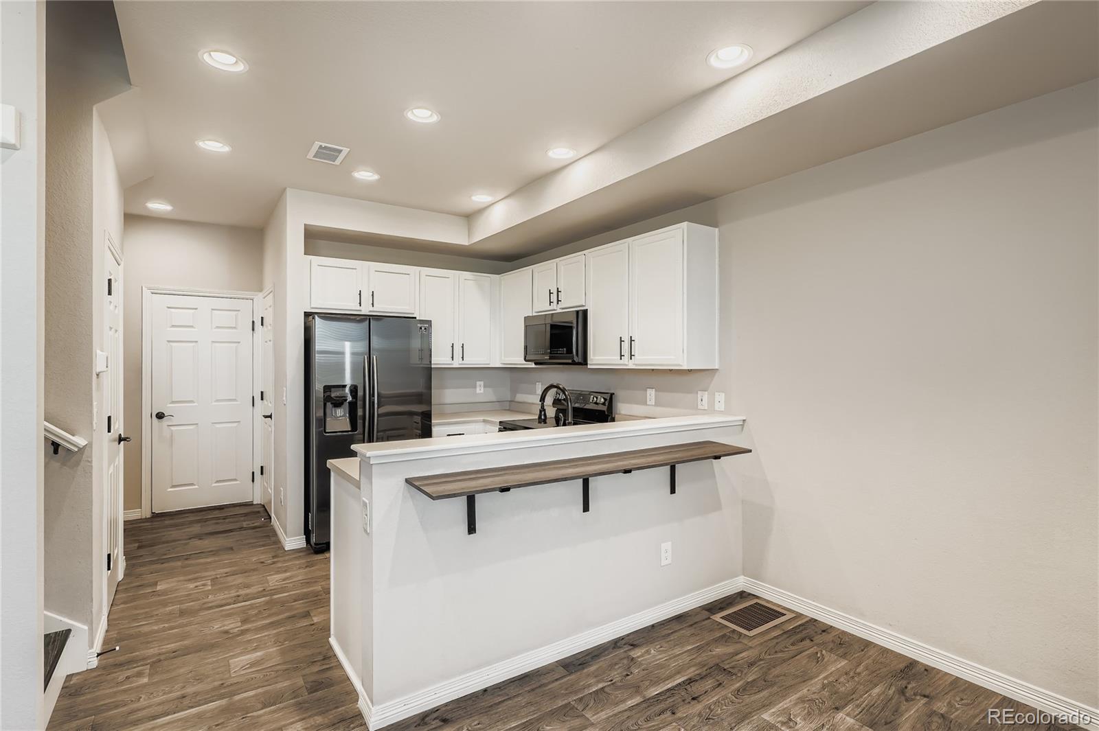 4767 Memphis Street Denver, CO 80239 - Photo 4 of 17 a kitchen with stainless steel appliances a refrigerator and a stove top oven
