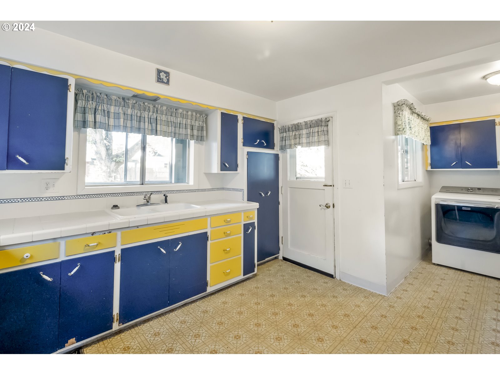 4417 Southeast 65th Avenue Portland, OR 97206 - Photo 14 of 38 a large kitchen with stainless steel appliances wooden cabinets a sink and a window