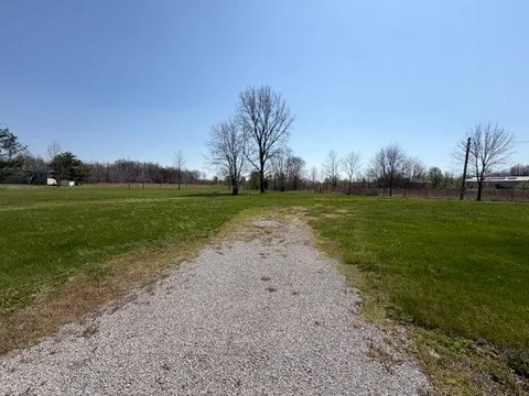 a view of a field with grass and a trees