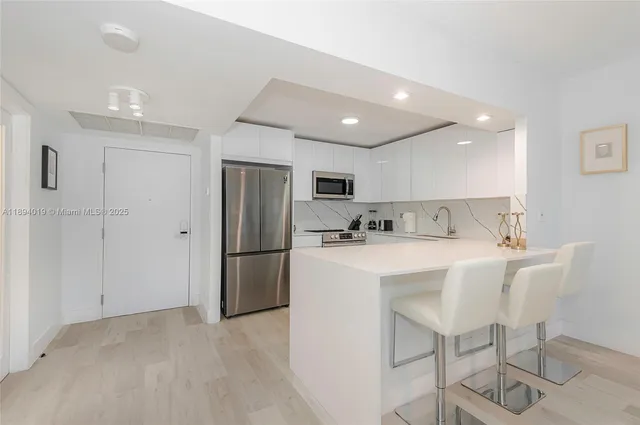 a view of kitchen with refrigerator sink and wooden cabinets