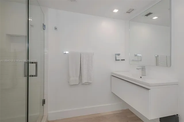 a bathroom with a sink a shower and a mirror
