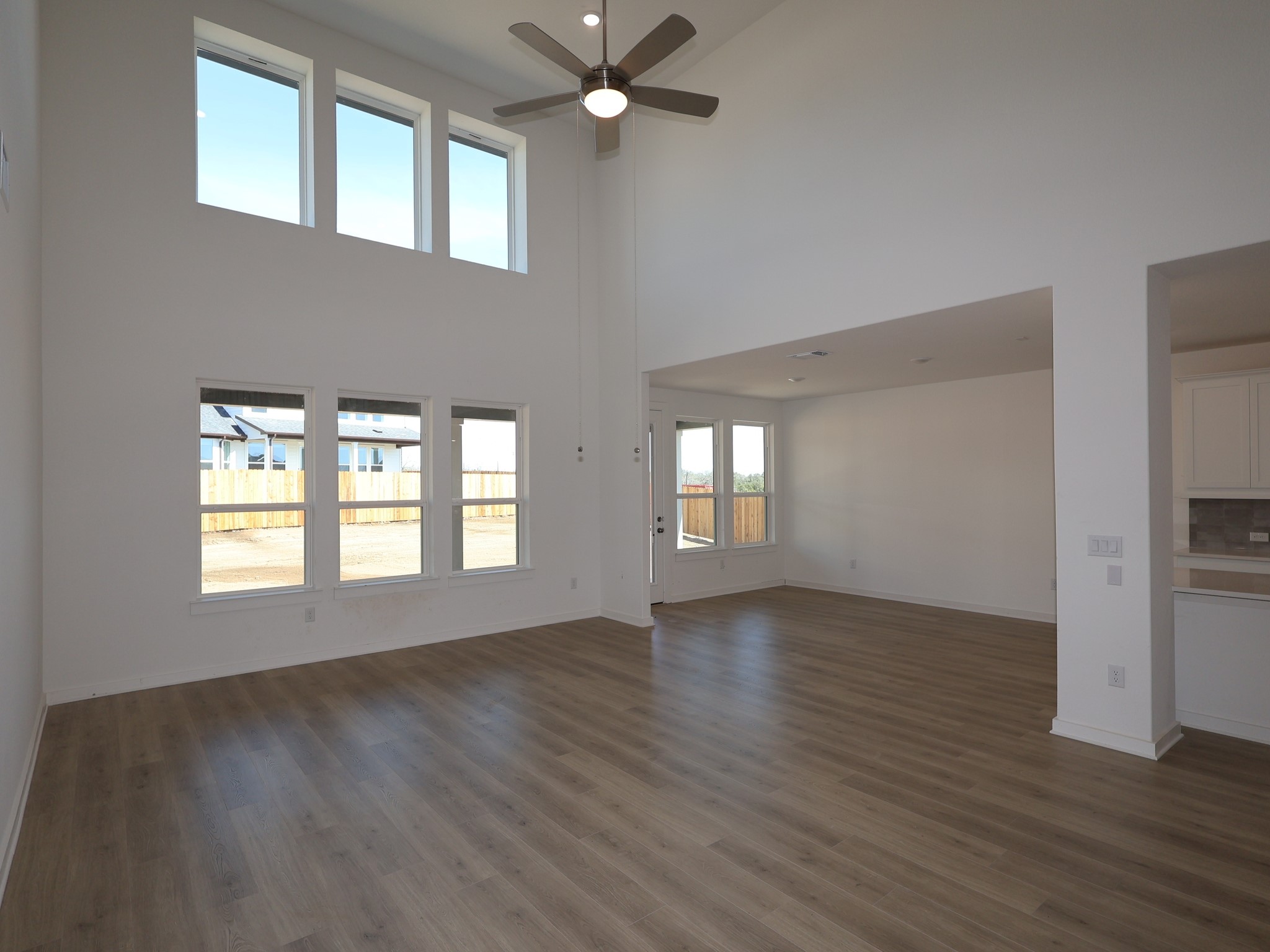 3977 Waco Way Leander, TX 78641 - Photo 3 of 23 a view of an empty room with a window and wooden floor