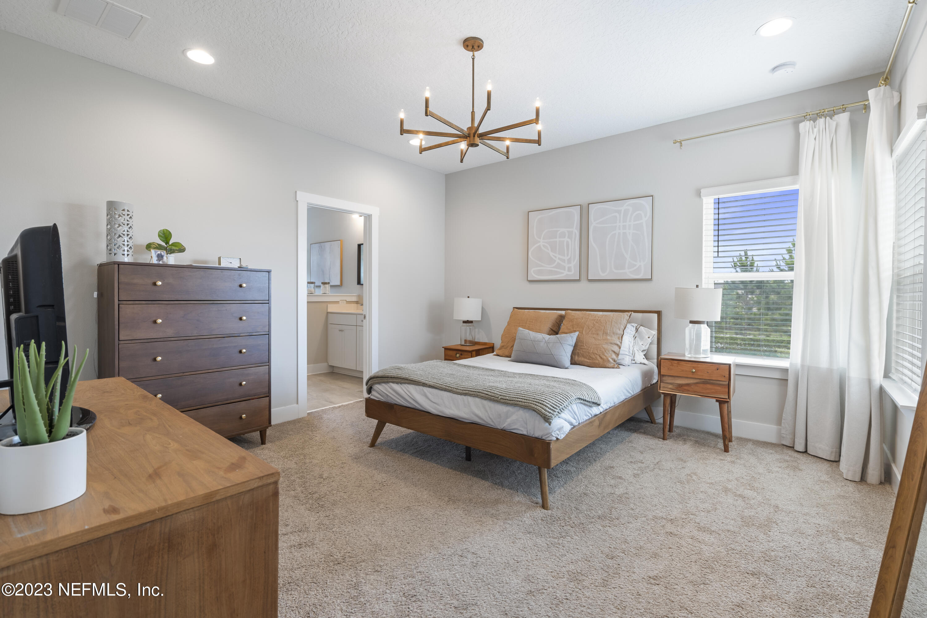36 Strobe Court St. Augustine, FL 32095 - Photo 4 of 47 a spacious bedroom with a bed and a chandelier