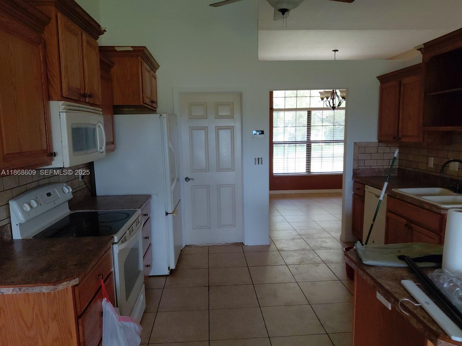 740 Arbuckle Creek Road Lorida, FL 33857 - Photo 5 of 21 a kitchen with granite countertop a stove and a refrigerator