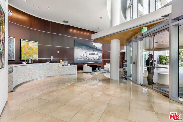 a view of a lobby with a chandelier and refrigerator