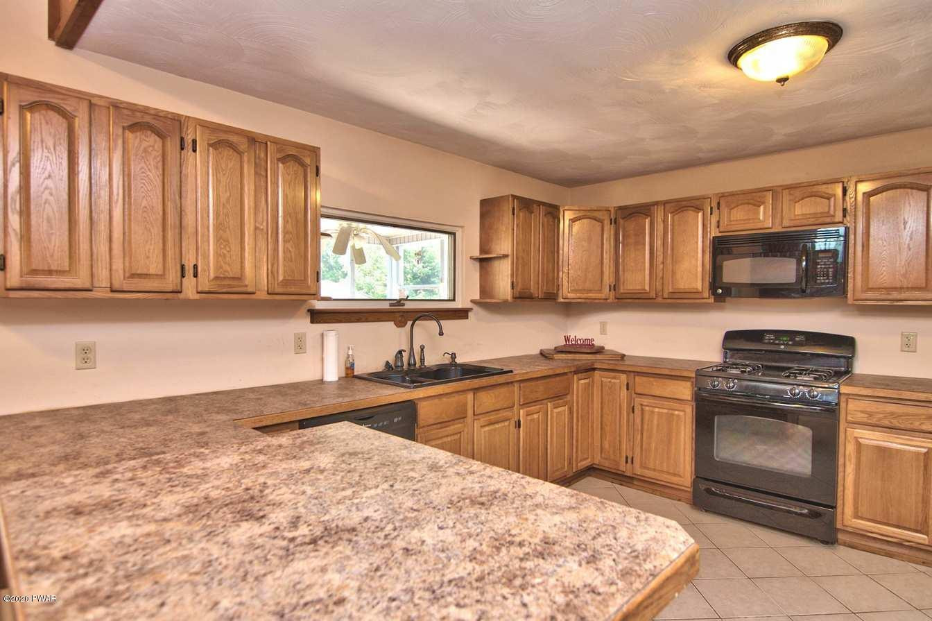 5690 Haas Pond Road Moscow, PA 18444 - Photo 21 of 79 a kitchen with stainless steel appliances granite countertop a stove sink microwave and cabinets