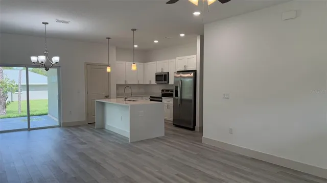 a view of kitchen with refrigerator and wooden floor