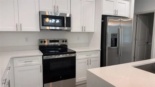 a kitchen with stainless steel appliances granite countertop a refrigerator stove and microwave