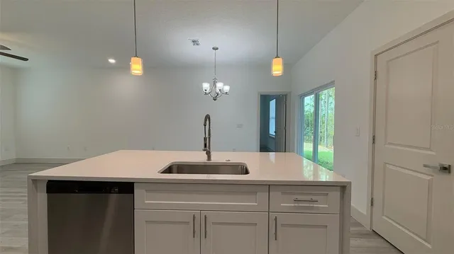 a kitchen with a sink and a chandelier