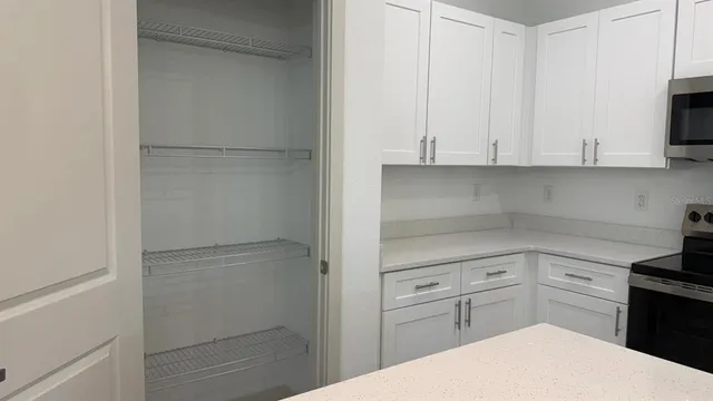 a kitchen with white cabinets and white appliances