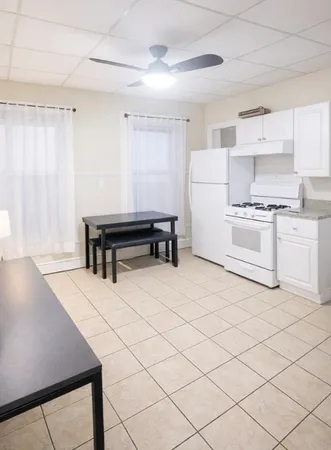 a kitchen with a sink a stove and white cabinets