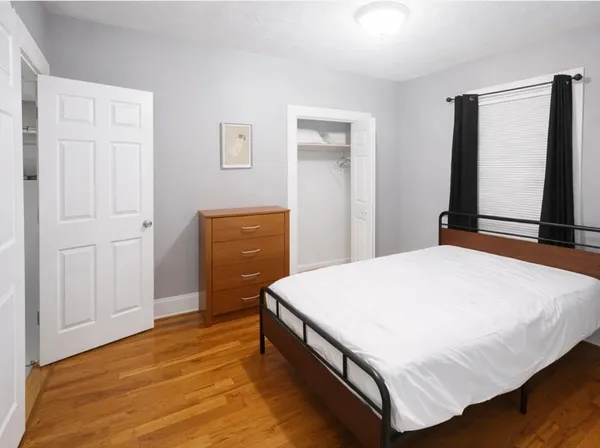 a bedroom with a bed and dresser with mirror