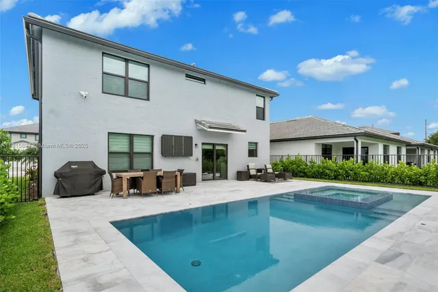 a view of a house with swimming pool and sitting area