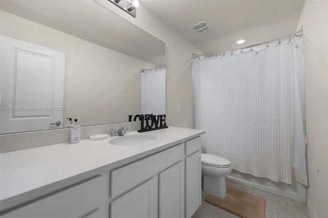 a bathroom with a sink toilet vanity and shower