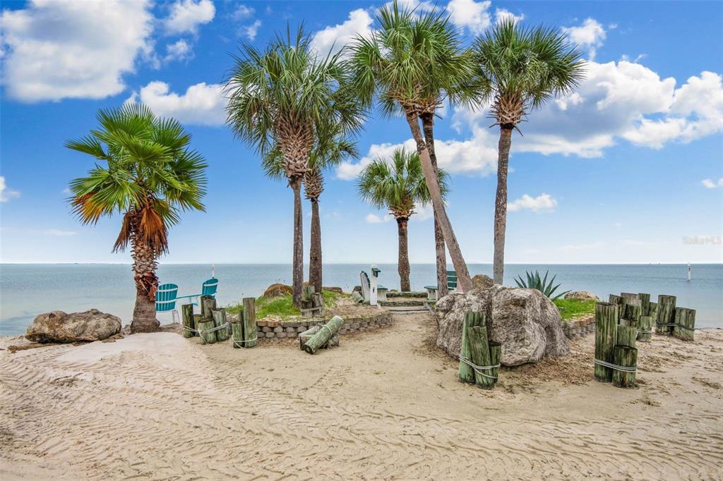 4832 Jasper Drive, Unit 107 New Port Richey, FL 34652 - Photo 25 of 27 a view of a backyard of a house with lawn chairs under an umbrella