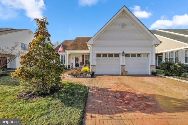 a front view of a house with a yard and potted plants