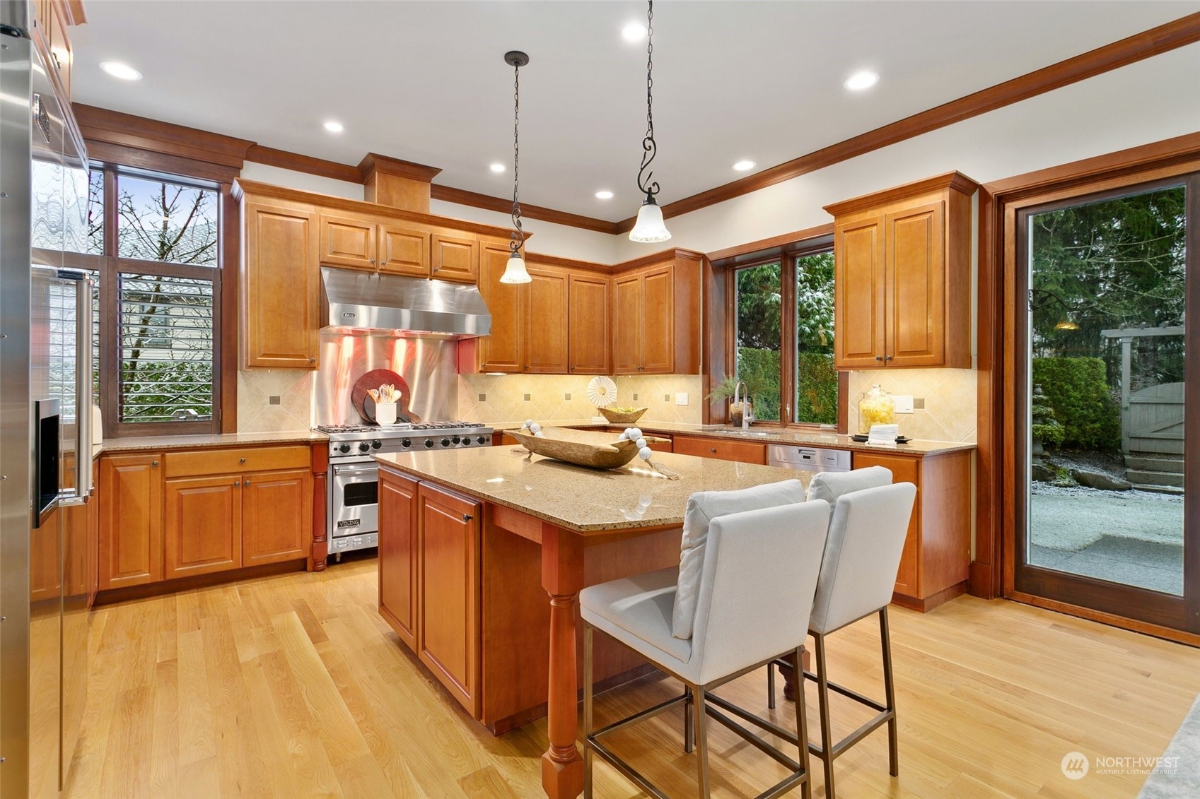 573 Saddleback Loop Way Northwest Issaquah, WA 98027 - Photo 12 of 40 a kitchen with stainless steel appliances granite countertop a stove a sink a refrigerator a dining table and chairs with wooden floor