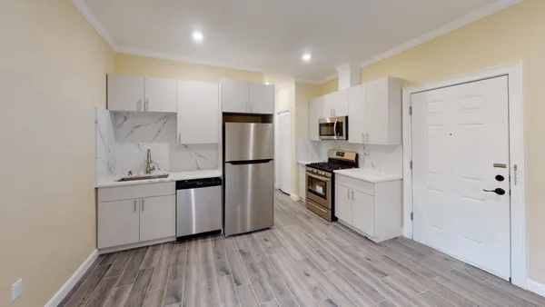 a kitchen with a refrigerator and a stove top oven
