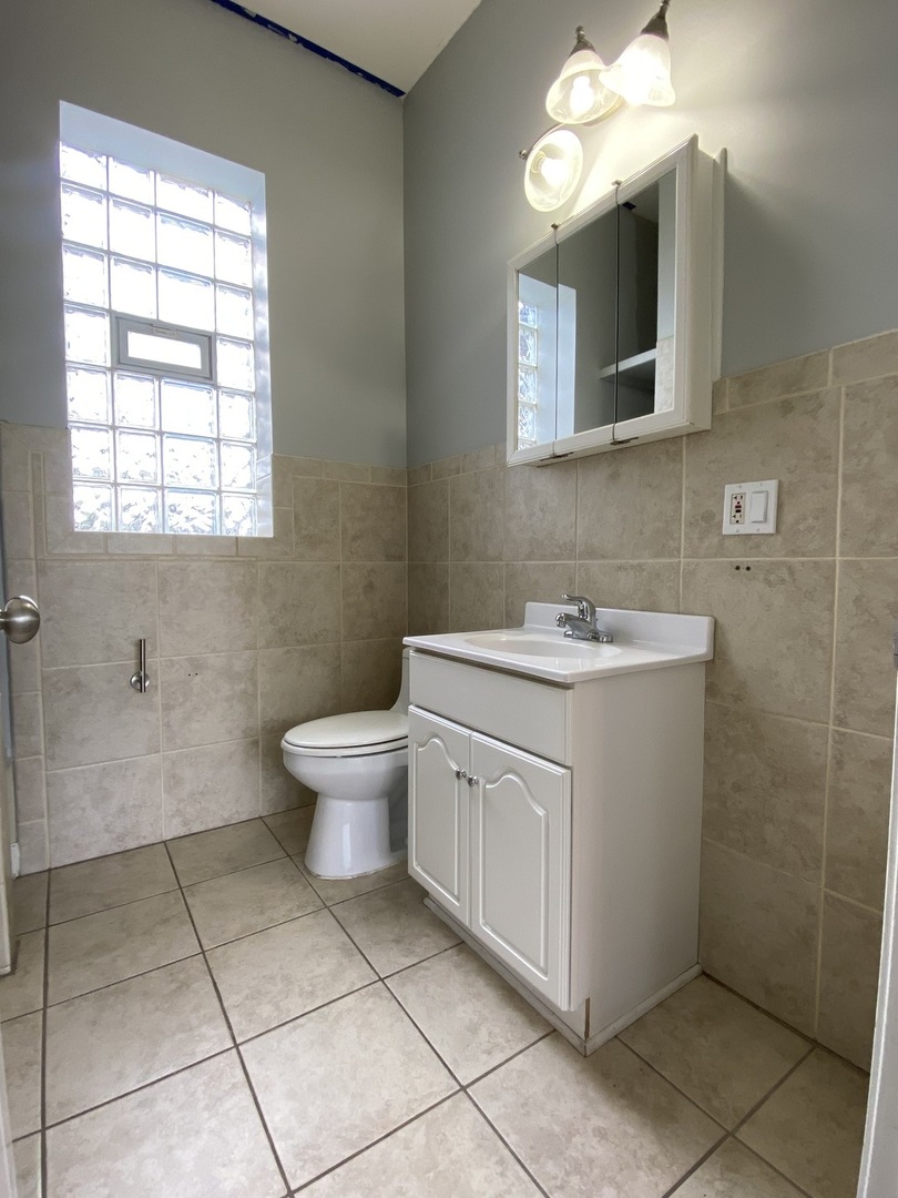 Undisclosed Address Chicago, IL 60622 - Photo 11 of 18 a bathroom with a toilet sink and mirror