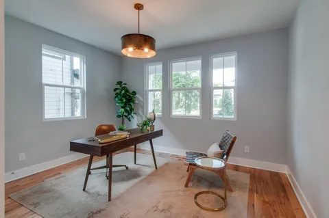 a workspace with furniture a potted plant and a chandelier