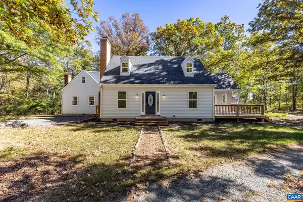 a view of a house with a large tree and a yard