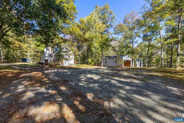 a view of an empty room with wooden floor fireplace and a window